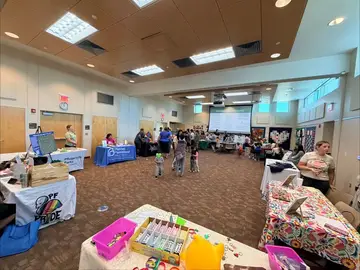 Families visiting nonprofit resource tables at the People Pfirst Pflugerville CommUNITY Fair