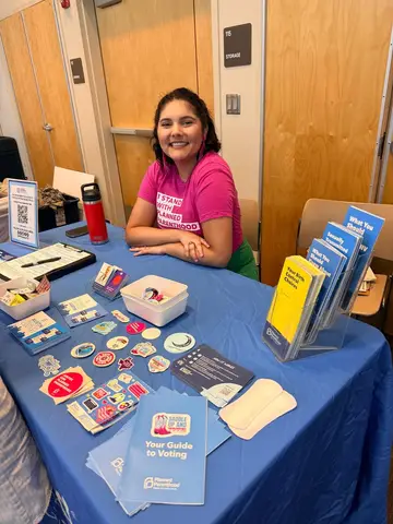 A nonprofit representative sharing health and voting resources at the CommUNITY Fair