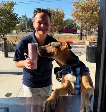 Jonathan Coffman greeting a dog at a local coffee window