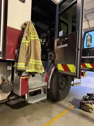 Pflugerville firefighter coat hanging on a fire truck during a station visit