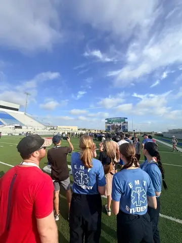 Participants and student emergency medical technicians gathering on the football field before the September 11 memorial stair climb