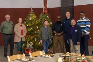 Community leaders gathered near decorated holiday trees