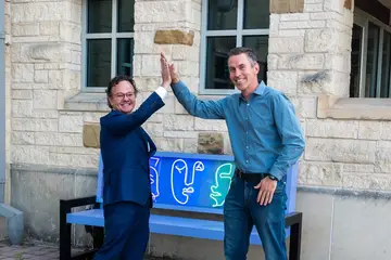 Jonathan Coffman high-fiving another attendee outside Old Gregg during Pflugerville's Goodbye Flock party