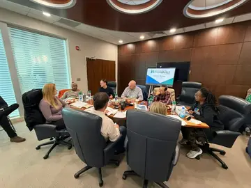 Pflugerville council members and staff seated around a table at a council retreat